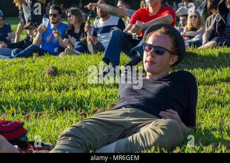 Mann auf Gras beobachten Konzert im Music Festival liegen Stockfoto