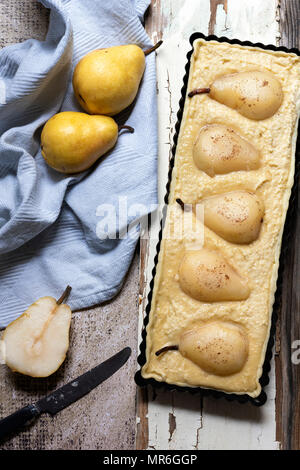 Ungekocht rechteckige pear Tart mit zwei reife Birnen und ein Messer. Stockfoto