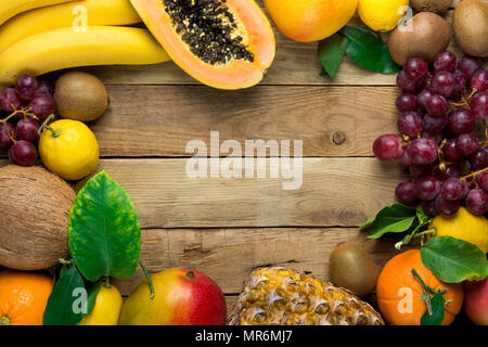 Rahmen mit Kopieren aus frischen tropischen und Sommer Früchte Ananas Papaya Mango Coconut Orangen, Kiwi, Bananen, Zitronen Pampelmusen und Grapefruits auf Vintage Plank Woo Stockfoto