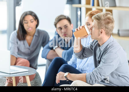Geschäftsmann trinkt Kaffee während der Konferenz Stockfoto