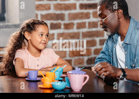 African American Girl in Tea Party mit Vater zu Hause Stockfoto