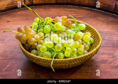 Die Trauben der roten und grünen Sorten von Trauben auf einem holzfass Stockfoto