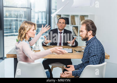 Seitenansicht des paar Argument während der Besprechung mit dem Rechtsanwalt im Büro Stockfoto
