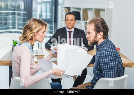Seitenansicht des paar Argument während der Besprechung mit dem Rechtsanwalt im Büro Stockfoto
