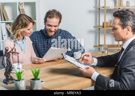 Selektiver Fokus der lächelnde Paar lesen Vertrag beim Treffen mit dem Rechtsanwalt im Büro Stockfoto