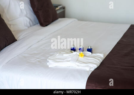 Bad Ausstattung mit Bademantel auf dem Bett im Hotel Zimmer Stockfoto
