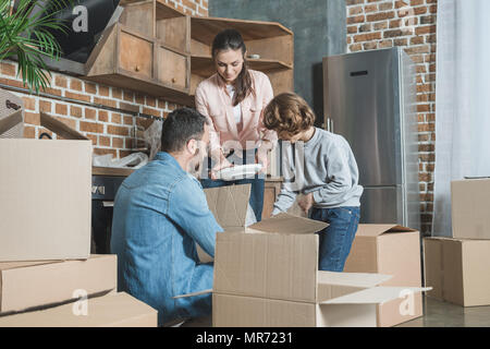 Glückliche Familie Auspacken der Kartons in neues Haus Stockfoto