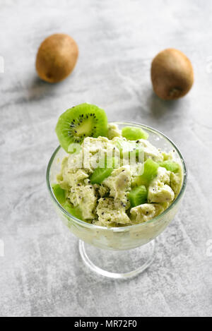 Kiwi Eis in Glas Schüssel auf Tisch aus Stein. Lecker Sommer Nachtisch. Stockfoto
