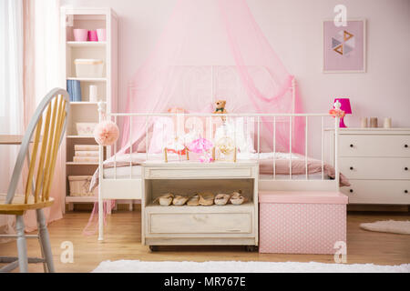 Rosa Schlafzimmer mit Himmelbett und weißen Möbeln Stockfoto