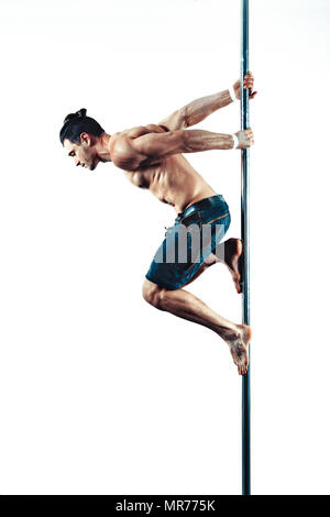 Junge starke Pole Dancing man auf weißer Wand Hintergrund Stockfoto