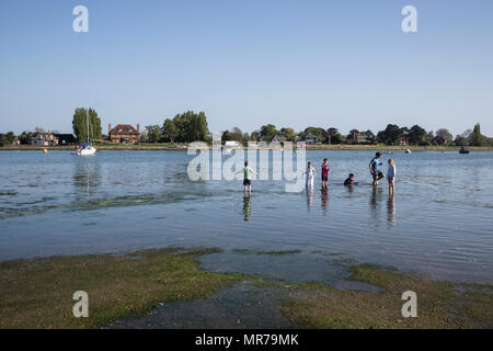 Kinder spielen im Meer bei Ebbe an Bosham, in der Nähe von Chichester, Sussex, UK Stockfoto