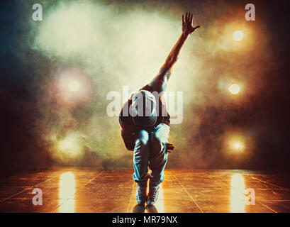 Junger Mann Breakdance im Club mit Licht und Rauch. Tattoo auf den Körper. Stockfoto