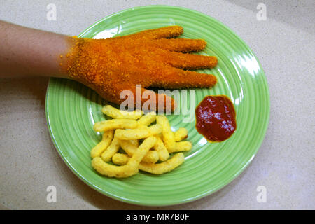 Hand bedeckt mit gebratene Brotkrumen (knusprig Aussehen sieht aus wie Schnitzel) auf einem grünen Schild mit Pommes und Ketchup. Stockfoto