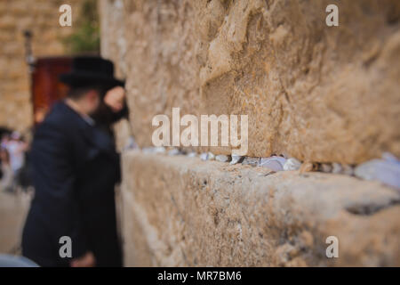 Religiöse orthodoxen Juden an der Klagemauer in der Altstadt von Jerusalem Israel zu beten. Es gibt Hinweise auf Gott in die Ritzen zwischen den Steinen. Stockfoto