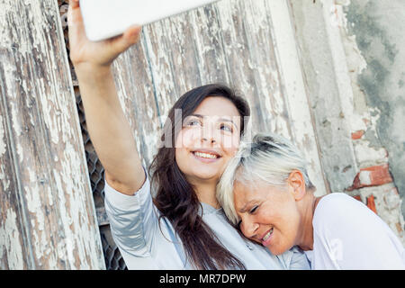 Mutter und erwachsene Tochter eine selfie im Freien Stockfoto