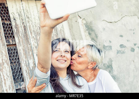 Mutter und erwachsene Tochter eine selfie im Freien Stockfoto