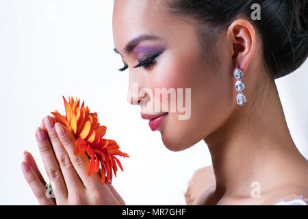 Junge asiatische Frau mit Blume Portrait auf weißem Hintergrund Stockfoto