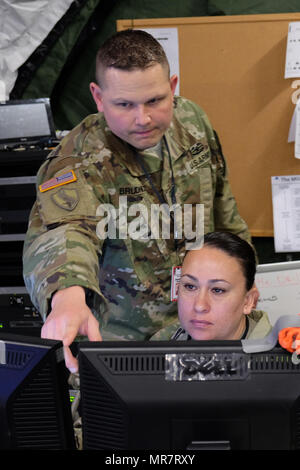 KAISERSLAUTERN, Deutschland - Master Sgt. Pierre Brudnicki, Links, und Sgt. 1. Klasse Brenda Vejar input Material in die Kommandozentrale der Zukunft computer system Samstag, 13. Mai 2017 während der 7. Mission Support Command Post Übung an Panzer Kaserne in Kaiserslautern. (Foto durch Oberstleutnant Jefferson Wolfe) Stockfoto