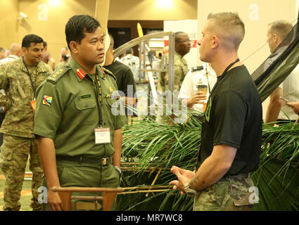 Staff Sgt. Shaun Thompson, ein Dschungel Schule Ausbilder mit 25 Infanterie Division Blitz Akademie, bespricht die Dschungel Schule Lehrplan zusammen mit Erfahrungen mit Kol. Haszaimi Bol Hassan, mit der Royal Brunei Land erzwingen, während das Land Forces Pacific (LANPAC) Symposium, 24. Mai im Sheraton Waikiki in Honolulu, HI. Us-Armee Führer, sowie gemeinsame und regionale Partner, diskutieren und präsentieren die entscheidende Rolle der Pazifischen Landstreitkräfte während der dreitägigen Veranstaltung. Stockfoto