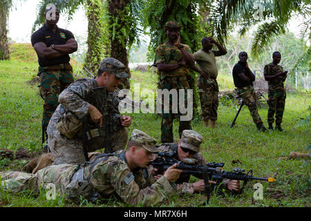 Ghanaische Streitkräfte Maj. Jakob Codjoe, Kommandant der Jungle Warfare School, überwacht der US-Soldaten aus dem 1 Battalion, 506Th Infantry Regiment, 1st Brigade Combat Team, Luftlandedivision, die Durchführung einer Hinterhalt Kurs während United Accord 2017 Jungle Warfare Schule in Achiase Militärbasis, Akim Oda, Ghana, 20. Mai 2017. Die Jungle Warfare School ist eine Reihe von situativen Übungen entwickelt, die Teilnehmer in die Train-Aufstand und die innere Sicherheit. (U.S. Armee Foto von SPC. Victor Perez Vargas) Stockfoto