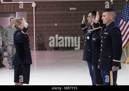 Major Barbara Coe, der taktische Offizier und Kommandant des Pre-OCS-Programms mit dem 207. Multifunktions Training Regiment verwaltet den Amtseid Officer Candidates Ivan Cuevas, Marisa Lindsay und David Notti während einer Inbetriebnahme Zeremonie in der National Guard Armory auf gemeinsamer Basis Elmendorf-Richardson, Alaska, 21. Mai 2017. Lt. Colonel Wayne Don, Kommandant des Befehls 38. Truppe war der Gastredner für die Zeremonie.    (US Army National Guard Foto von Spc. Michael Risinger) Stockfoto