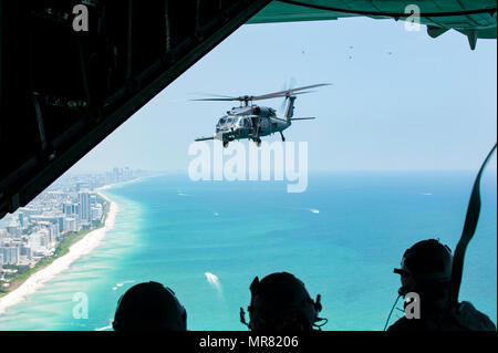 Das bodenpersonal mit Die 129 Rettung Flügel, aus Moffett Federal Airfield, Calif., sehen Sie sich ein HH-60G Pave Hawk von der Rückseite eines HC-130 P/N Kampf gegen König während der Nationalen begrüssen zu Amerikas Helden in der Luft und auf See Medien anzeigen Tag 26. Mai 2017 in Miami Beach, Fla. top tier militärischen US-Vermögenswerte in Miami zu Showcase Luftüberlegenheit zusammengebaut haben beim ehren diejenigen, die das ultimative Opfer während des Memorial Day Wochenende gemacht haben. Die 129 RQW mit zwei HH-60G Pave Hawk und vier A-10 Thunderbolt II Flugzeuge aus der Rettung 920th Wing und dem 442 d Fighter Wing beziehungsweise zu Schlagzeile die Stockfoto