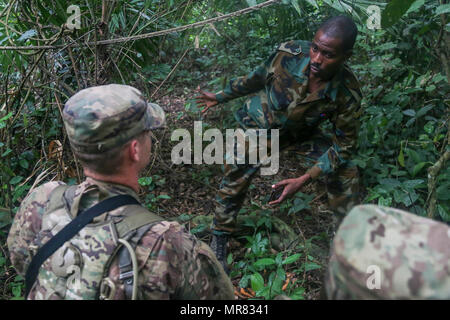 Ghana Armee Sgt. Kofi Francis Donkor erklärt Manöver Taktik, US Army Staff Sgt Ty Kurtz das 1. Bataillon, 506. Infanterieregiment, 1st Brigade Combat Team, 101. US-Luftlandedivision bei United Accord 2017 bei Jungle Warfare School auf die Militärbasis Achiase, Akim Oda, Ghana, 26. Mai 2017 zugewiesen. Jungle Warfare School ist eine Reihe von situative Übungen entwickelt, um Teilnehmer zur Niederschlagung von Aufständen und interne Sicherheitsmaßnahmen zu trainieren. (Foto: U.S. Army Sergeant Brian Chaney) Stockfoto