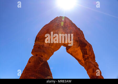Duschen die Sonne ihre Strahlen über den Höhepunkt der Zarten Arch Ausleuchten der Sandstein Formation mit beeindruckenden Farben Blau und Rot Stockfoto
