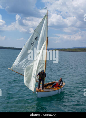 Klinker gebaut Holz- Jolle oder Yacht in Baltimore Harbor gesegelt werden, Irland durch ein Paar den Sommer genießen Wetter. Stockfoto