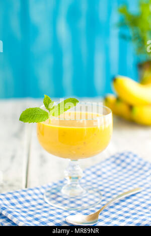 Bananen Smoothie und frische Banane auf hölzernen Tisch Stockfoto