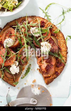 Gesunde quinoa Pizza mit Tomaten, getrocknete Tomaten, roquette Blätter und Ziegenkäse Stockfoto