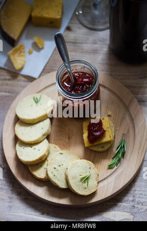 Rosmarin Cracker mit Cheddar auf Käsebrett mit süßen Tomaten relish Stockfoto