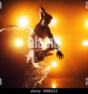 Junger Mann Breakdancer mit Licht- und Wassereffekte. Tattoo auf der Hand. Stockfoto