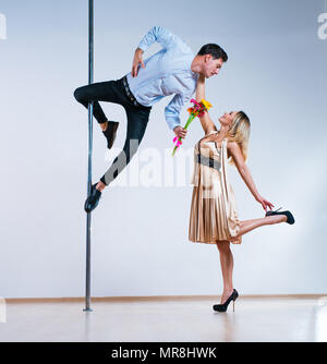 Junger Mann und Frau Pole Tänzer. Mann Blumen zu Frau. Liebe Konzept. Stockfoto