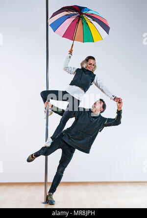 Junger Mann und Frau Pole Tänzer legere Kleidung Herbst mit Schirm Stockfoto