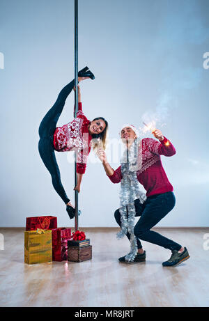 Junger Mann und Frau Pole Tänzer im Winter neues Jahr Kleidung feiern Stockfoto