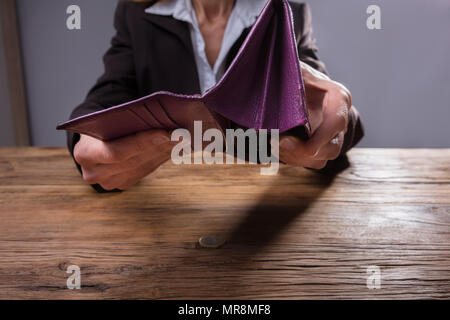 Nahaufnahme einer Hand, die leer ist ein Geschäftsmann, der Geldbeutel über Holz- Schreibtisch Stockfoto