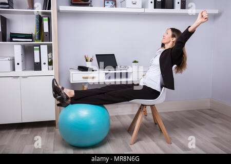 Seitenansicht eines entspannten Geschäftsfrau recken ihre Arme Stockfoto