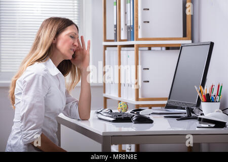 Seitenansicht eines reifen Geschäftsfrau Kopfschmerzen Leiden am Arbeitsplatz Stockfoto