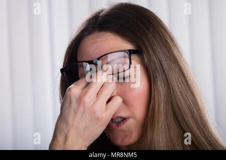 In der Nähe von Frau mit Brillen über den Kopf, die Augen mit der Hand Stockfoto