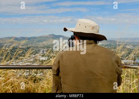 Mann mit Stativ, Fotos von Townsville Vororten zu nehmen, fotografiert von hinten, Castle Hill, QLD 4810, Australien Stockfoto