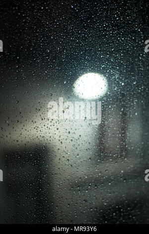 Regentropfen am Fenster in der Nacht in Brüssel Stockfoto