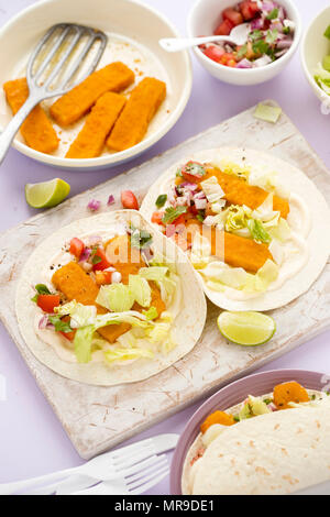 Fischstäbchen öffnen Tortillas, Tacos auf würziger Mayonnaise und Salat mit roten Zwiebeln, grüne und rote Paprika Salat Stockfoto