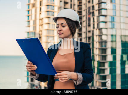 Wunderschöne Business woman Ingenieur steht mit plan Papiere. Stockfoto