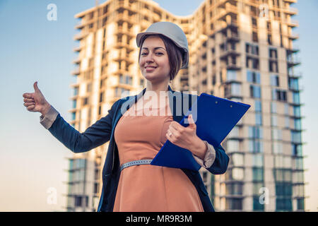 Wunderschöne Business woman Ingenieur steht mit plan Papiere. Stockfoto