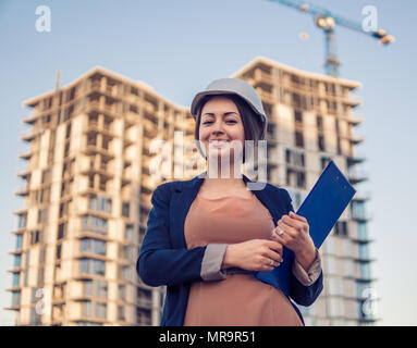 Wunderschöne Business woman Ingenieur steht mit plan Papiere. Stockfoto