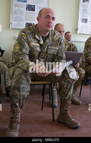 Ukrainische Oberstleutnant Pavlo Rozhko, Leiter des Zentrums Kampftraining am Yavoriv, Ukraine, wertet ukrainischen Stabsoffiziere des 1. Bataillons Airborne, 79. Air Assault Brigade während ihrer Mission Analyse Slips.    USA, Großbritannien, polnischen, litauischen und kanadischen Mentoren zugewiesen, gemeinsame multinationale Ausbildung Gruppe und der Ukraine führen Klassenzimmer Ausbildung des Personals im Rahmen der Mission Gesamtziel zu professionalisieren und bauen die Ausbildungskapazitäten der ukrainischen Armee. Stockfoto