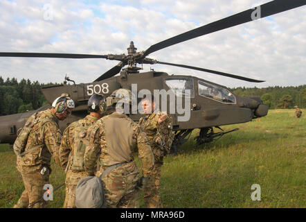 Kapitän Kris Halvorson, AH-64D Apache longbow Pilot mit dem ersten Angriff Reconnaissance Bataillon, 501St Aviation Regiment, 1st Armored Division, trifft sich mit dem Bodenpersonal am Joint Multinational Readiness Training Center, Hohenfels, Deutschland, 2. Juni 2017. Die Soldaten waren eine Ausbildung, Bewaffnung und Tanken Punkt erweiterte Manöver Ausbildung Lane als Teil des kombinierten Lösen VIII, eine Übung mit mehr als 3.400 Teilnehmern aus zehn NATO-Staaten zusammen, um die Bereitschaft und die Interoperabilität zu verbessern. (U.S. Army National Guard Foto von Sgt. Zane Craig) Stockfoto