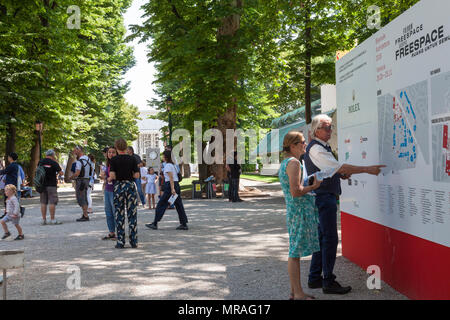 Venedig, Venetien, Italien. 26. Mai 2018. Der Eröffnungstag der 2018 Architektur Biennale berechtigt Freespace in Giardini Pubblici (öffentliche Gärten) Castello. Mitarbeiter Anzeigen des Information Board mit dem Venedig bennale Pavillion am Ende der Baum sichtbar gesäumten Allee. Kredit MLCpicsAlamy leben Nachrichten Stockfoto