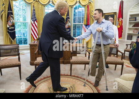 WASHINGTON, DC - IN DER WOCHE VOM 21. MAI: Präsident Donald J. Trumpf schüttelt Hände mit US-Armee SSG Matthew Haggart von Brunnen, CO, ein verwundeter Krieger Patienten vom Walter Reed National Military Medical Center, verbunden mit einem Besuch im Weißen Haus von US Air Force SSgt Aaron Metzger von Ray Stadt, GA; US-Armee MSG Jon Befugnisse von Sanford, NC, und ihre Familienangehörigen, die im Oval Office, Mittwoch, Mai 23, 2018, in Washington, D.C Personen: Präsident Donald Trump Stockfoto